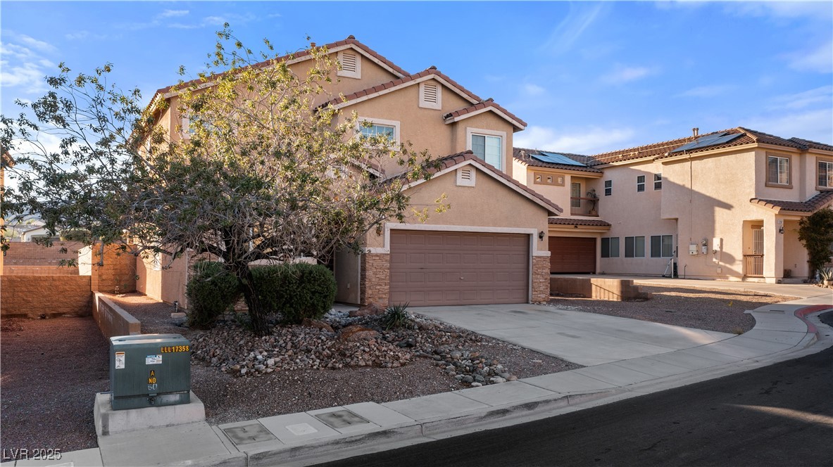 2715 Brinkley Manor Street Laughlin, NV 89029 - Photo 89 of 89 Mediterranean / spanish home featuring concrete driveway, stone siding, stucco siding, and a tiled roof