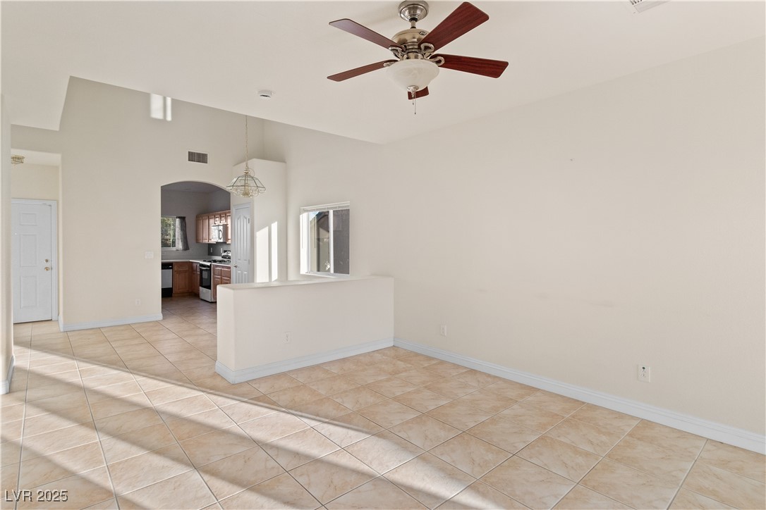 2715 Brinkley Manor Street Laughlin, NV 89029 - Photo 9 of 89 Living room with ceiling fan, arched walkways, a towering ceiling, and light tile patterned flooring