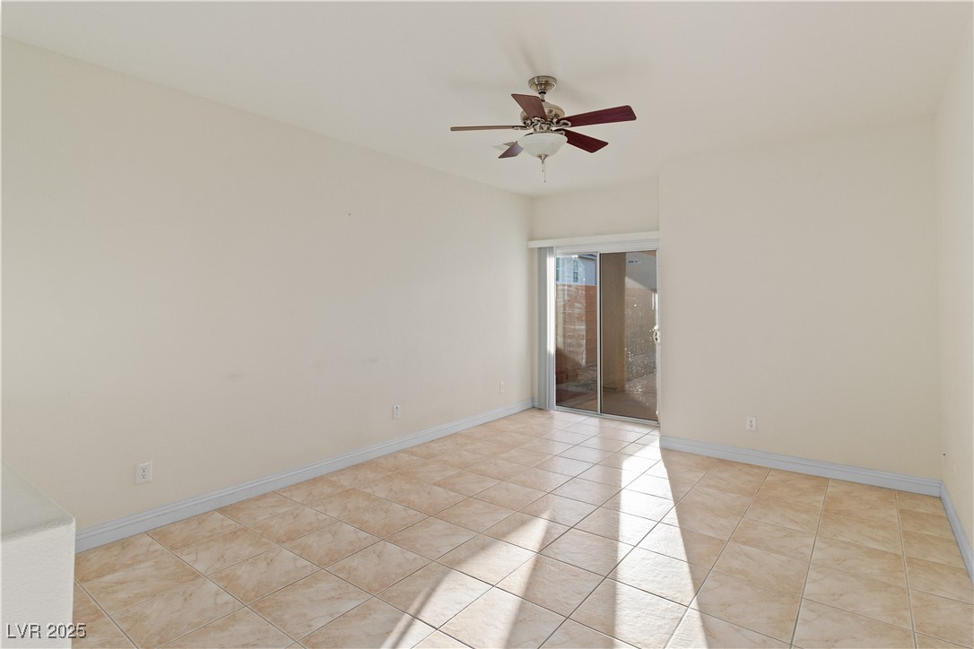2715 Brinkley Manor Street Laughlin, NV 89029 - Photo 10 of 89 Living room featuring a ceiling fan and baseboards, with the sliding glass door to the backyard