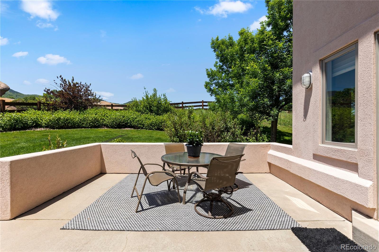 69 North Ranch Road Littleton, CO 80127 - Photo 45 of 50 a view of a patio with table and chairs and potted plants with wooden floor and fence