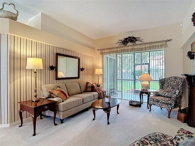 a kitchen with stainless steel appliances granite countertop a refrigerator a stove a sink and white cabinets with wooden floor