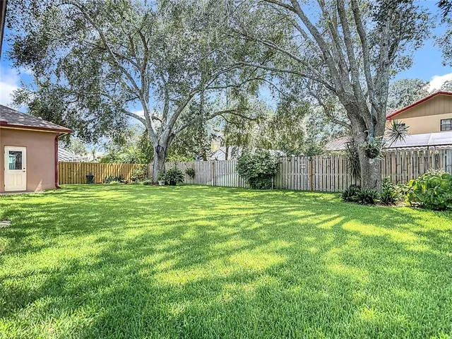 an aerial view of residential house with outdoor space and trees all around