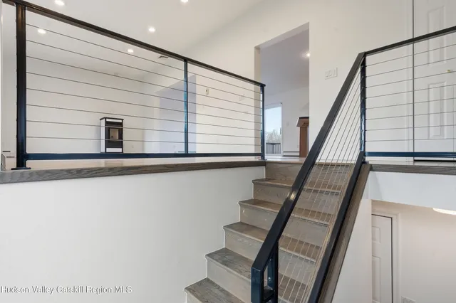 a view of hallway with stairs and wooden floor