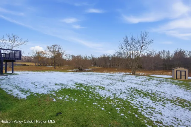 a view of dirt field with wooden fence