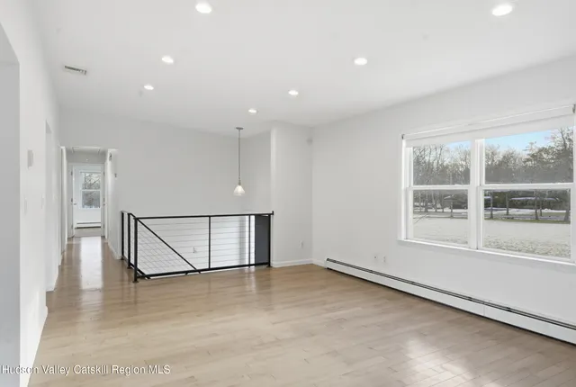 a view of empty room with wooden floor