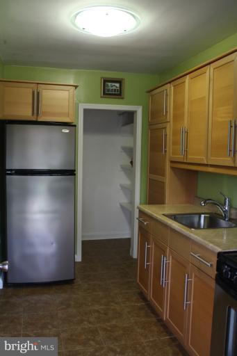 749 Arncliffe Road Baltimore, MD 21221 - Photo 14 of 20 a kitchen with stainless steel appliances granite countertop a refrigerator a stove and a sink with wooden cabinets