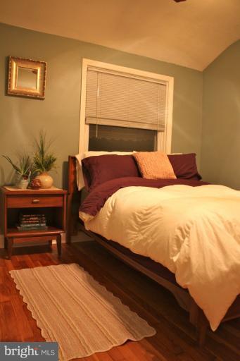 749 Arncliffe Road Baltimore, MD 21221 - Photo 18 of 20 a bedroom with a bed and dresser with wooden floor