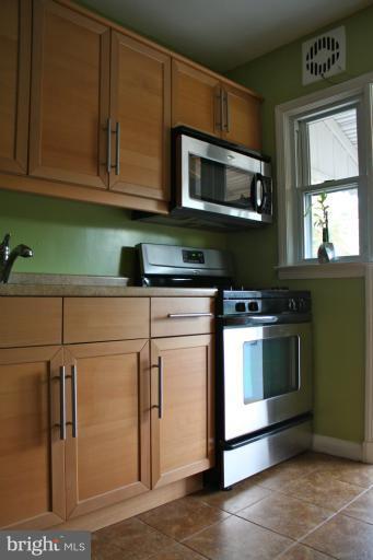 749 Arncliffe Road Baltimore, MD 21221 - Photo 3 of 20 a kitchen with stainless steel appliances granite countertop a stove microwave and cabinets