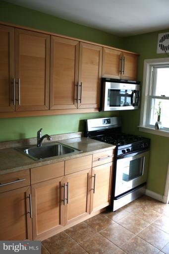 749 Arncliffe Road Baltimore, MD 21221 - Photo 6 of 20 a kitchen with stainless steel appliances granite countertop a sink stove and microwave