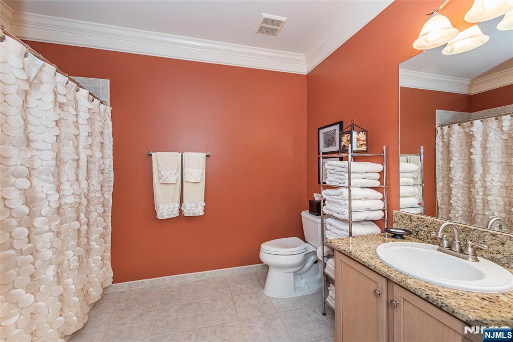 6105 Harcourt Road Clifton, NJ 07013 - Photo 18 of 23 a bathroom with a granite countertop sink toilet and mirror