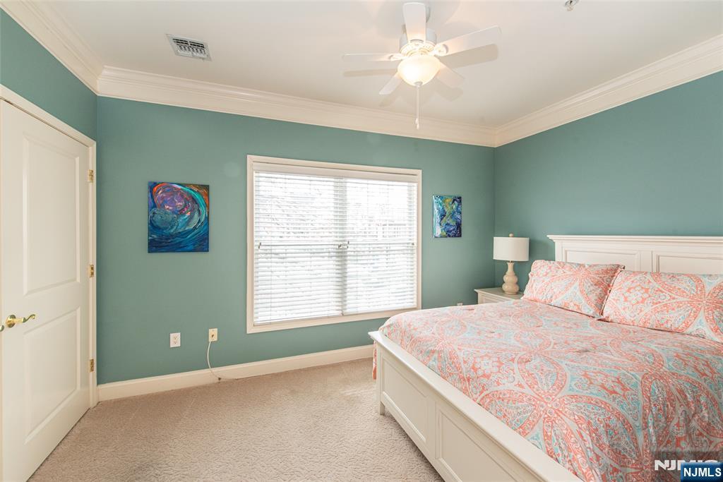 6105 Harcourt Road Clifton, NJ 07013 - Photo 20 of 23 a bedroom with a large bed and a chandelier