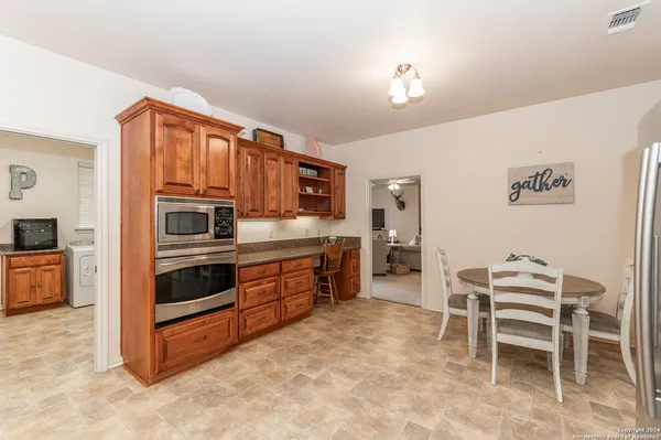 a kitchen with stainless steel appliances a stove a sink refrigerator and a chair