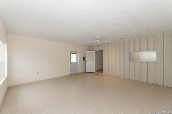 an empty room with windows and ceiling fan view