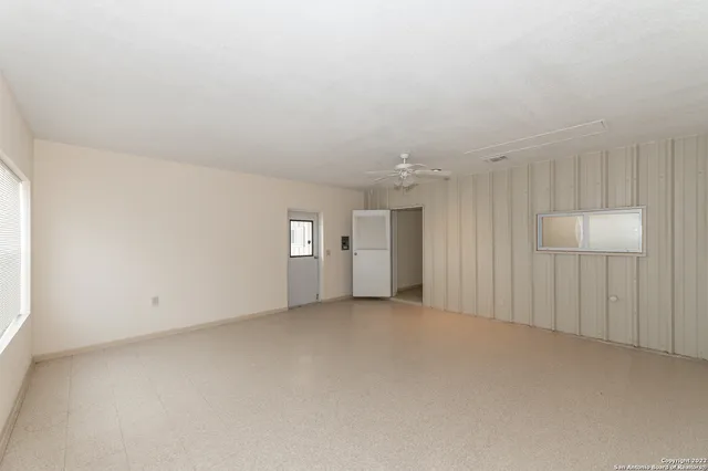 an empty room with windows and ceiling fan view
