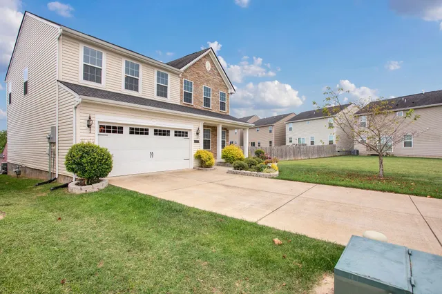 a view of an house with backyard and tree s
