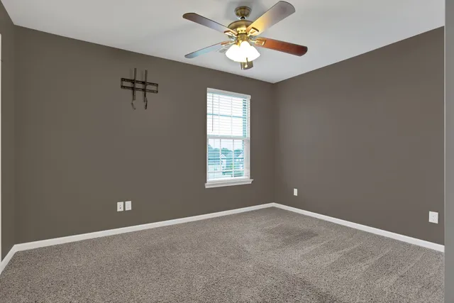 an empty room with closet and a chandelier fan