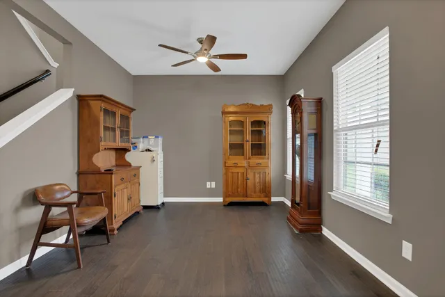 a living room with furniture ceiling fan and a window