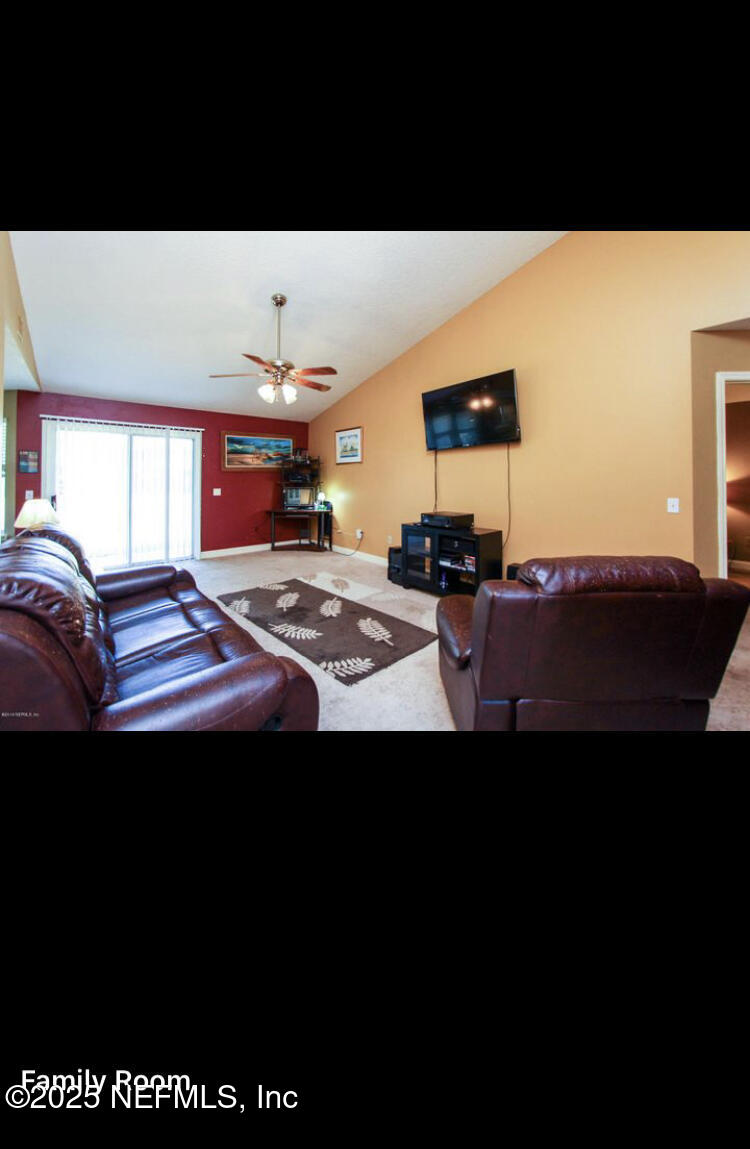 1000 Fleming Street Fleming Island, FL 32003 - Photo 2 of 17 a living room with a bed furniture and a flat screen tv
