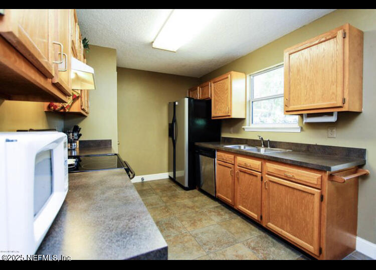 1000 Fleming Street Fleming Island, FL 32003 - Photo 4 of 17 a kitchen with stainless steel appliances granite countertop a stove a sink and a refrigerator