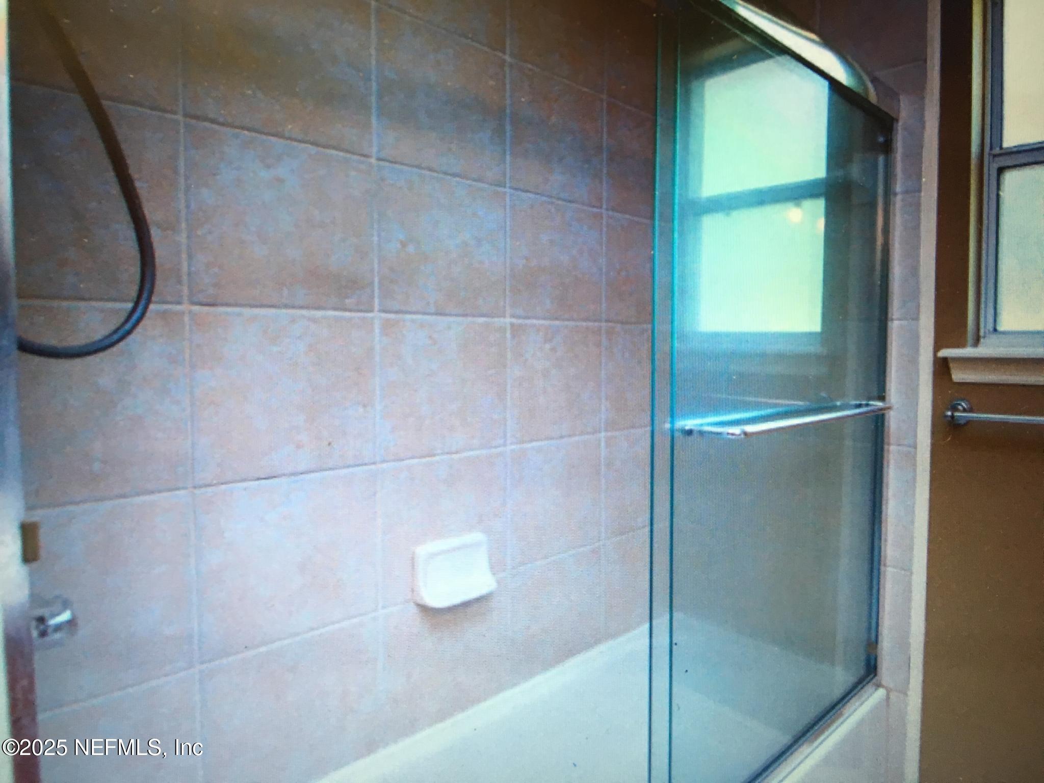 1000 Fleming Street Fleming Island, FL 32003 - Photo 7 of 17 a bathroom with a glass shower door