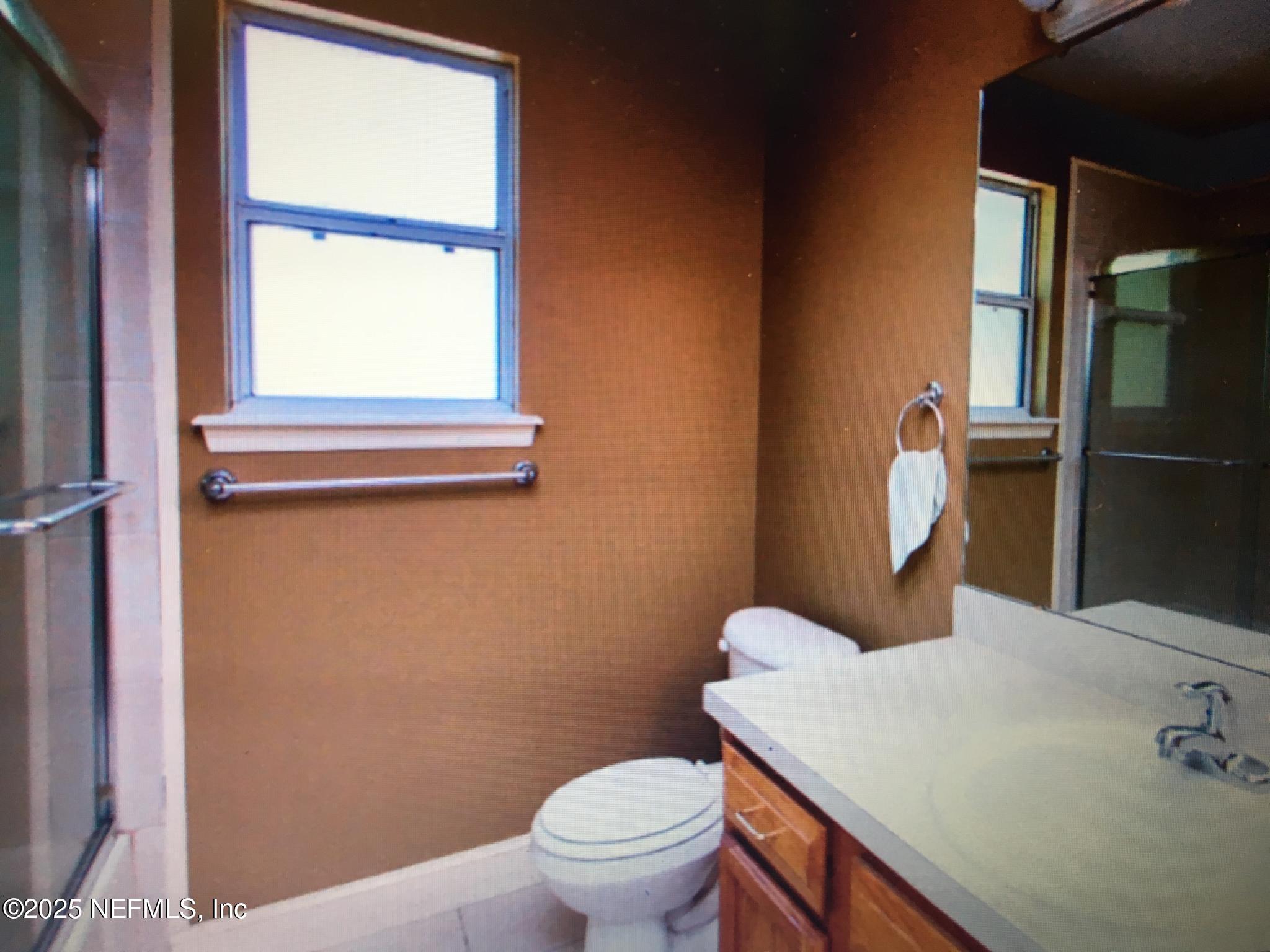1000 Fleming Street Fleming Island, FL 32003 - Photo 8 of 17 a bathroom with a toilet a sink and a window