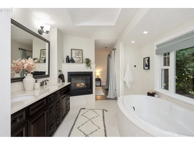 a spacious bathroom with a bathtub double sink shower and mirror