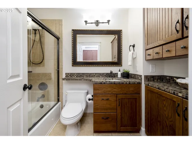 a bathroom with a granite countertop sink toilet and shower