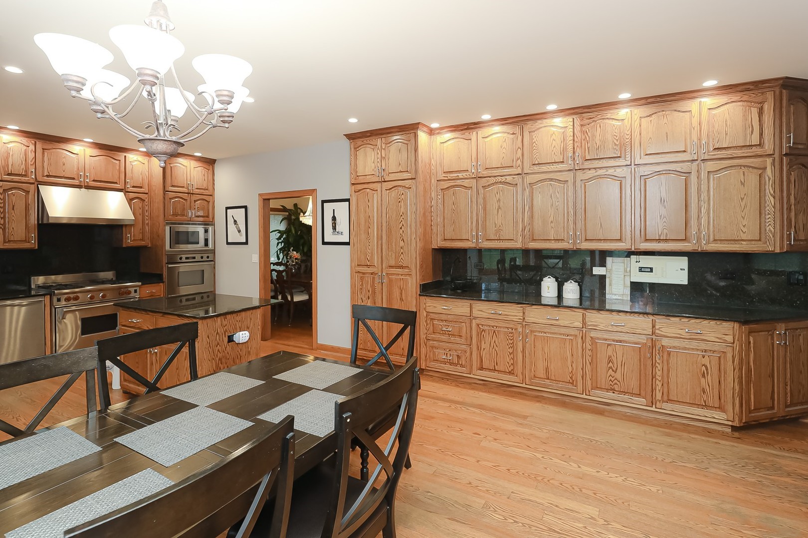307 79th Street Burr Ridge, IL 60527 - Photo 13 of 41 a kitchen with stainless steel appliances kitchen island granite countertop a refrigerator a stove a sink dishwasher and white cabinets with wooden floor