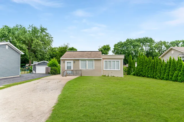 a front view of a house with a yard and trees