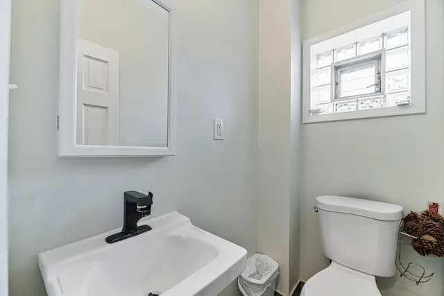 a bathroom with a toilet sink and mirror