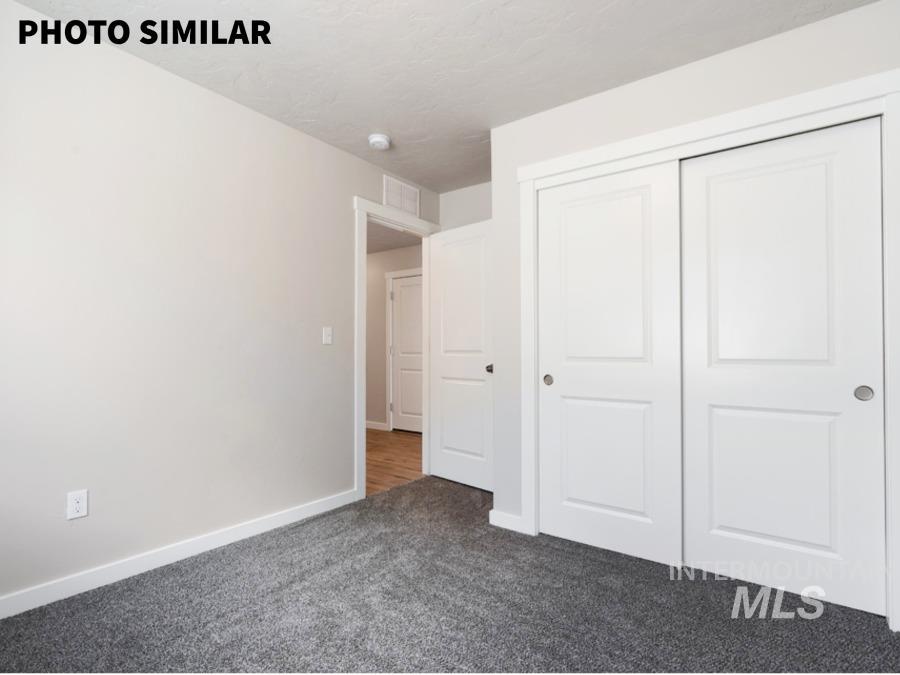 925 Twilight Weiser, ID 83672 - Photo 27 of 31 Neutral-toned room featuring a dark gray carpet, white baseboards, and a white sliding closet door with panel detailing