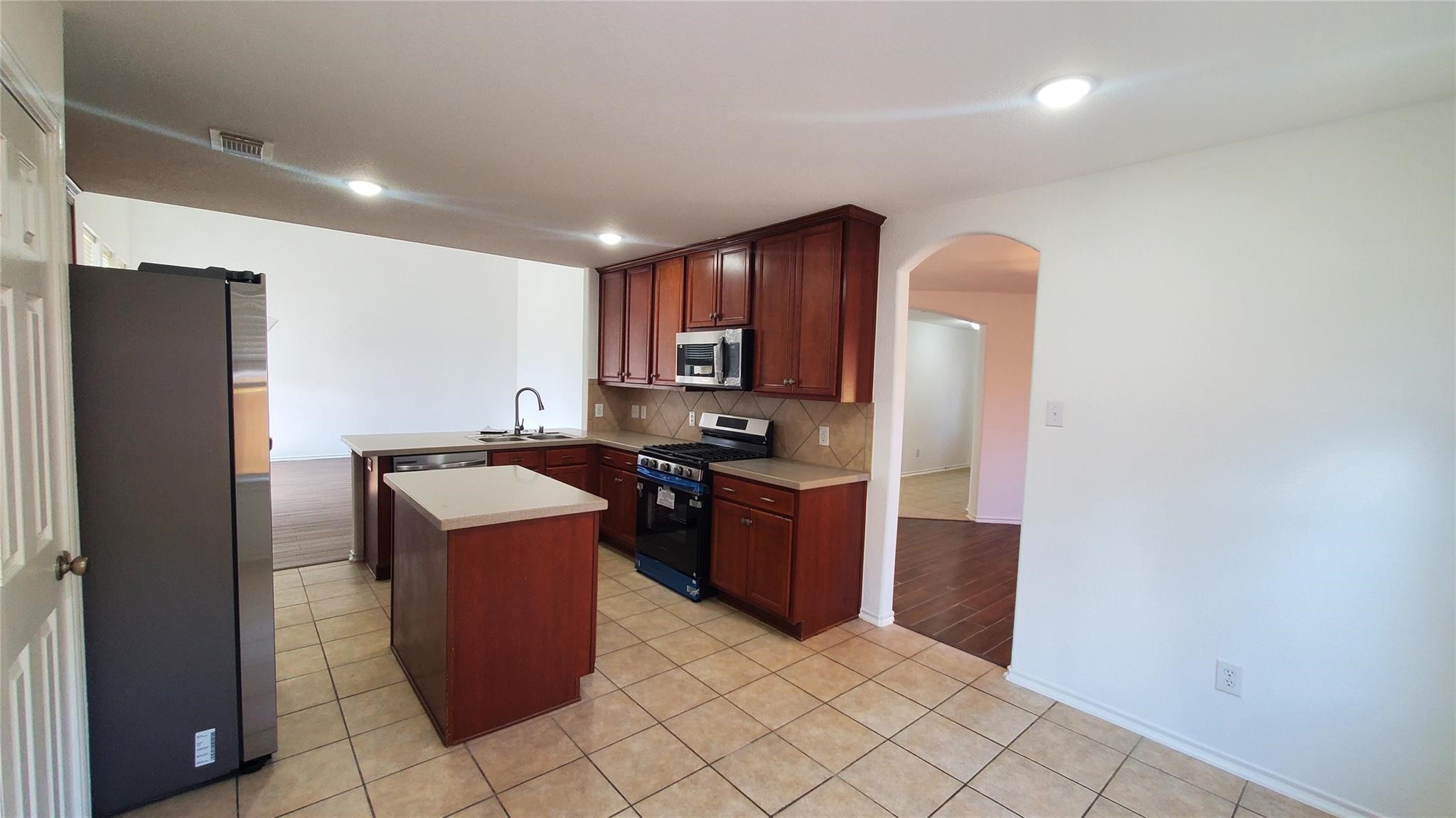 2814 Silver Point Lane Rosharon, TX 77583 - Photo 3 of 29 a kitchen with stainless steel appliances granite countertop a refrigerator a stove a sink and a microwave