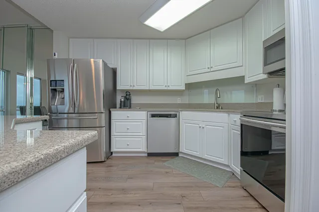a kitchen with white cabinets and stainless steel appliances