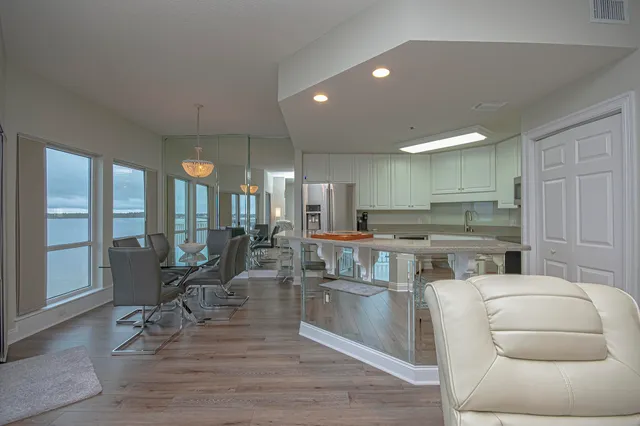 a kitchen with stainless steel appliances wooden floor dining table and chairs