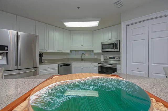 a kitchen with kitchen island a stove a microwave and a refrigerator