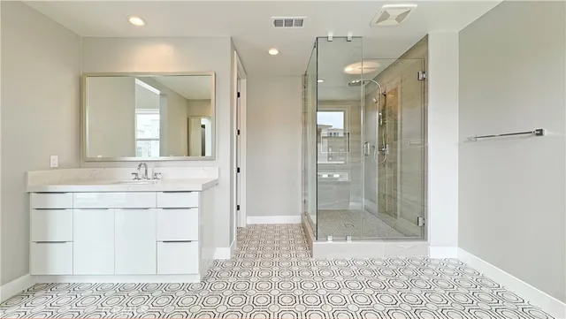 a bathroom with a granite countertop sink mirror and shower