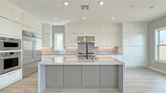 a kitchen with kitchen island granite countertop a stove a sink and a refrigerator
