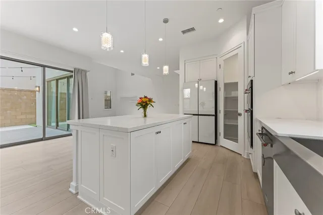 a large white kitchen with cabinets a sink and stainless steel appliances