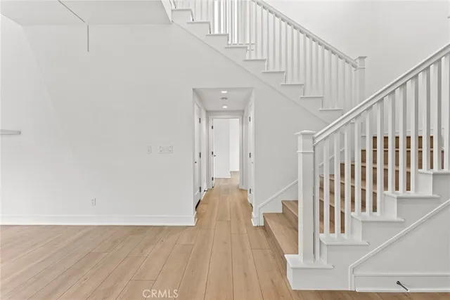 a view of staircase with white walls and wooden floor
