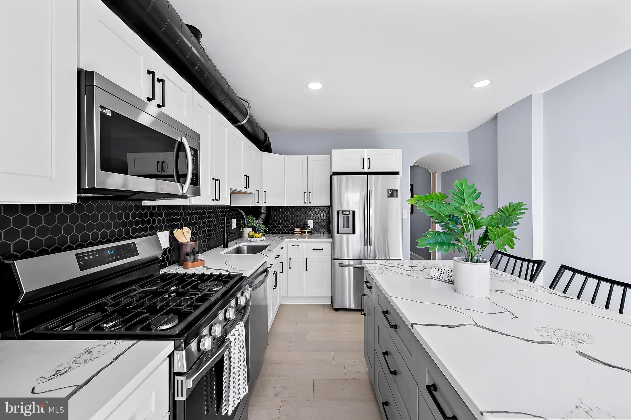 3137 Keswick Road Baltimore, MD 21211 - Photo 8 of 31 a kitchen with a stove a sink and a microwave
