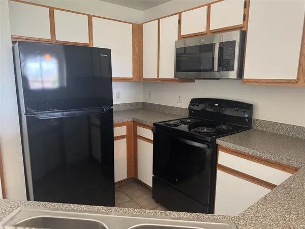 a kitchen with stainless steel appliances granite countertop a refrigerator and a microwave