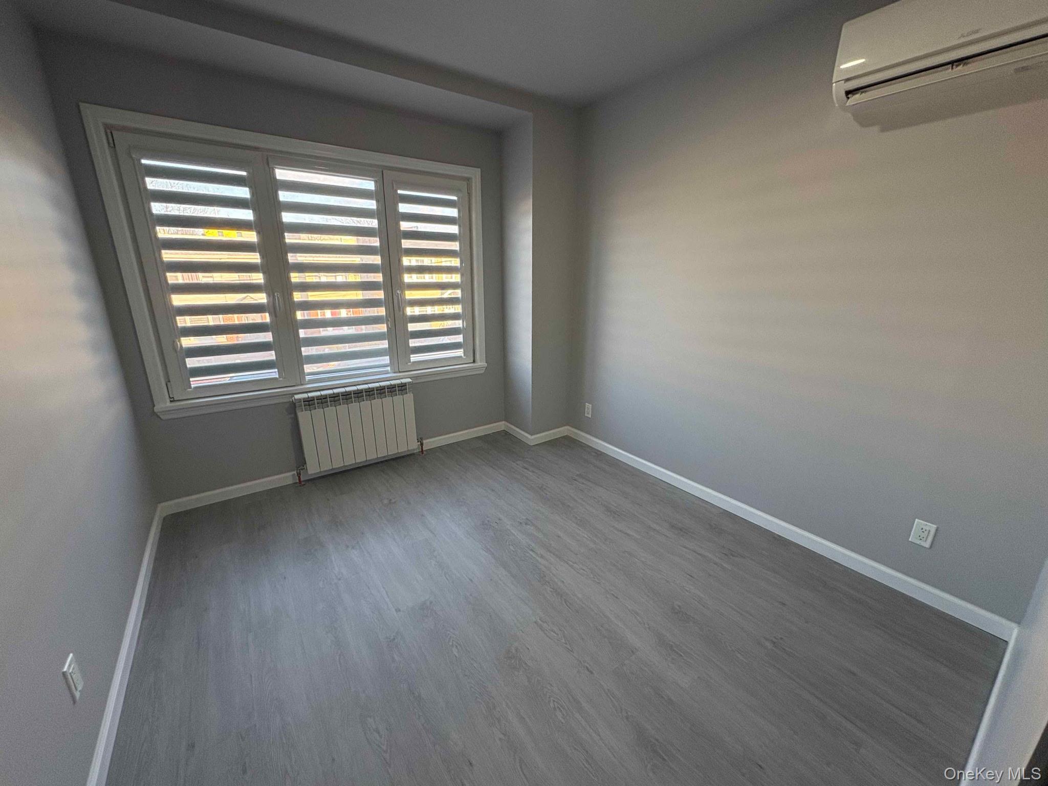 58-46 Fresh Pond Road, Unit 2 Queens, NY 11378 - Photo 3 of 9 a view of an empty room with wooden floor and a window