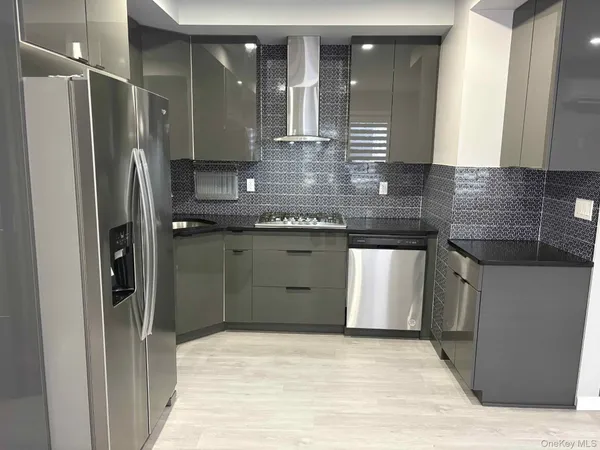 a kitchen with stainless steel appliances granite countertop a refrigerator and a sink