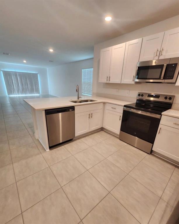 208 Acorn Road Haines City, FL 33844 - Photo 12 of 14 a kitchen with stainless steel appliances granite countertop a sink and a stove