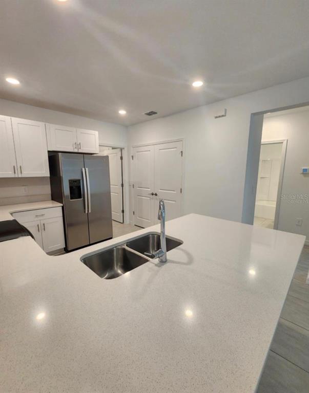 208 Acorn Road Haines City, FL 33844 - Photo 13 of 14 a kitchen with stainless steel appliances a sink a refrigerator and a stove