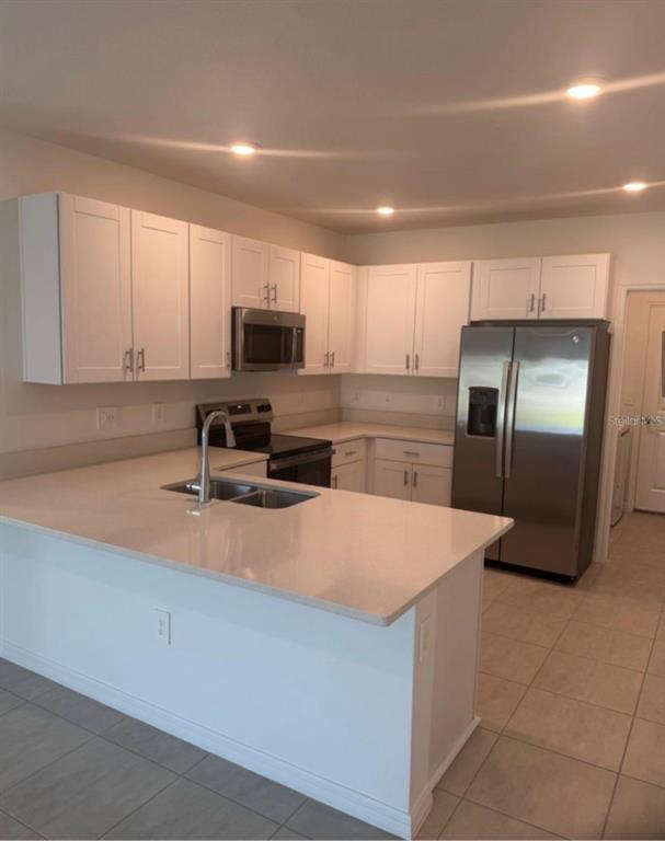 208 Acorn Road Haines City, FL 33844 - Photo 7 of 14 a kitchen with stainless steel appliances a refrigerator sink and microwave