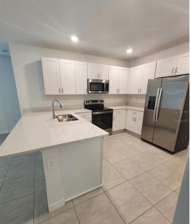 208 Acorn Road Haines City, FL 33844 - Photo 10 of 14 a kitchen with a sink a refrigerator and cabinets