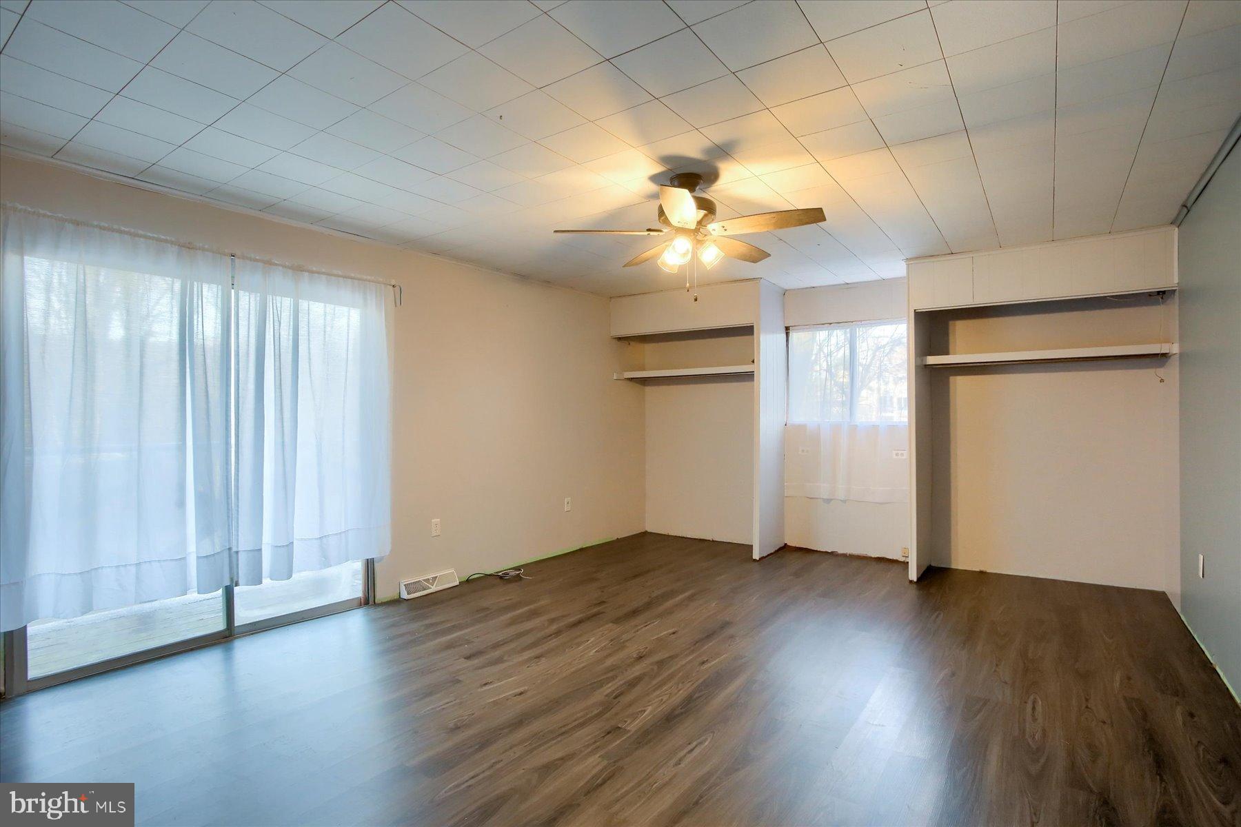 5404 Laurie Lane Enola, PA 17025 - Photo 17 of 29 an empty room with wooden floor chandelier fan and windows