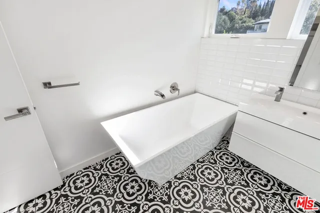 a bathroom with a sink and mirror with toilet