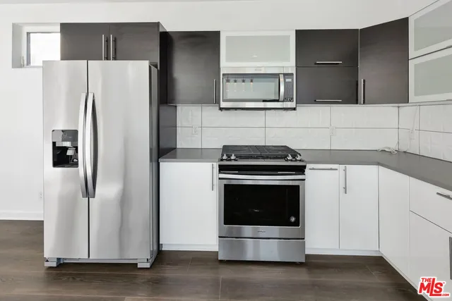 a kitchen with stainless steel appliances a refrigerator stove and microwave